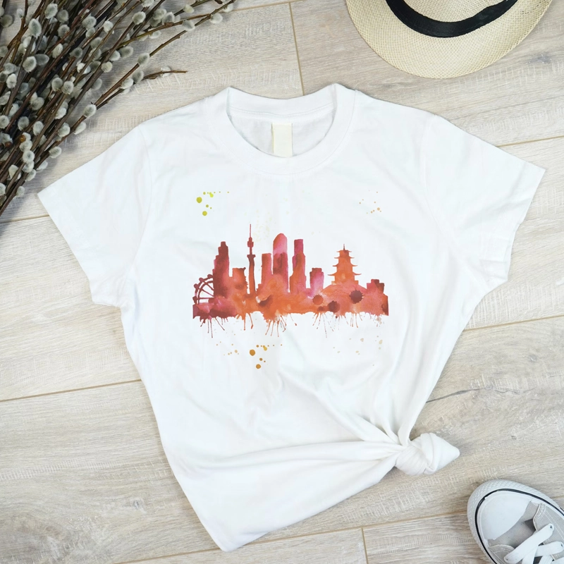 white t shirt with urban city paint in red watercolor. the is place on wooden floor.
